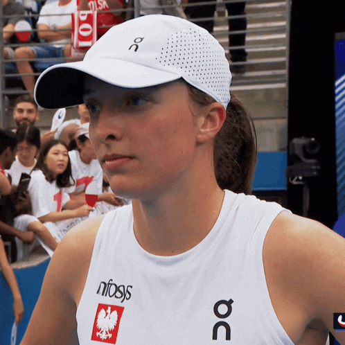 a woman wearing a white hat and a white tank top that says nfogs on it