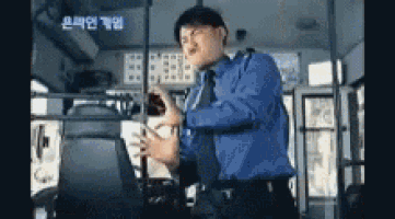 a man in a blue shirt and tie is driving a bus and making a funny face .