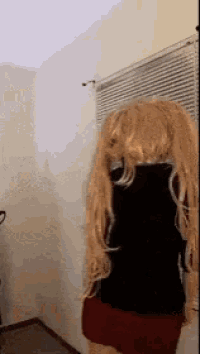 a woman wearing a wig is standing in front of a window .