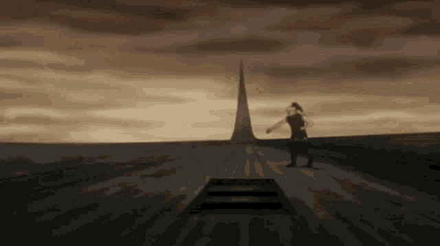 a person is standing on a wooden platform in front of a pyramid .