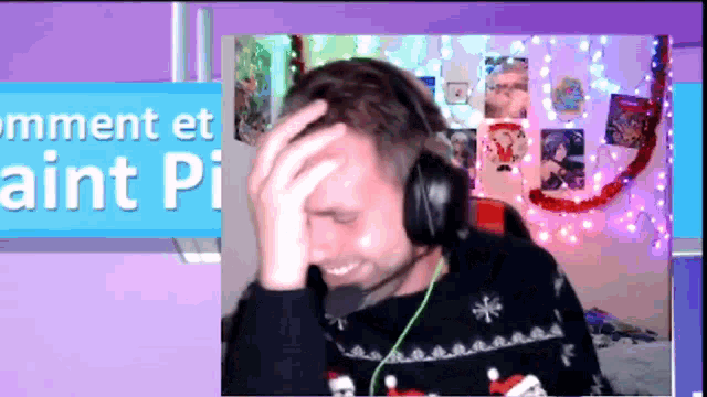 a man wearing headphones holds his hand to his forehead in front of a banner that says comment et aint pi