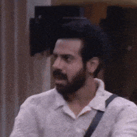 a man with a beard and a white shirt is walking down a street .