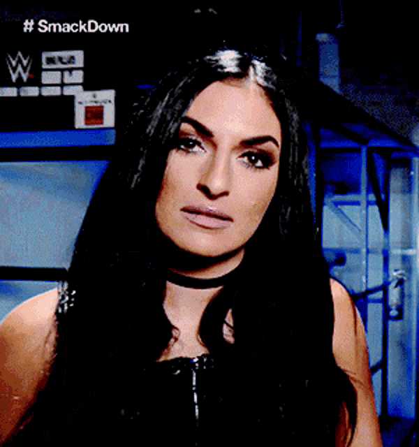 a woman stands in front of a sign that says # smackdown
