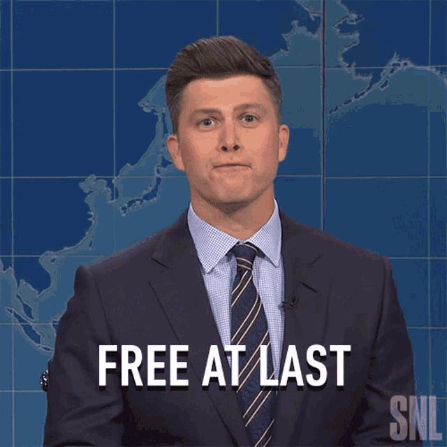 a man in a suit and tie says " free at last " in front of a map