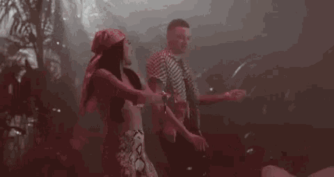a man and a woman are dancing together in a dark room in a video .
