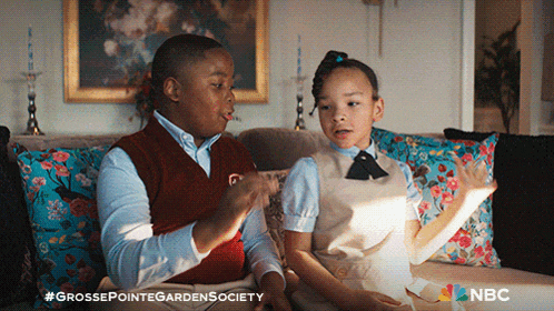 a boy and a girl are sitting on a couch with nbc written on the bottom