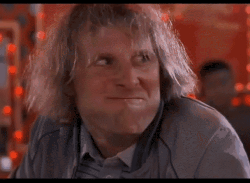 a man with curly hair is making a funny face and looking at the camera