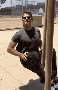 a man is sitting on a pole with his legs crossed .