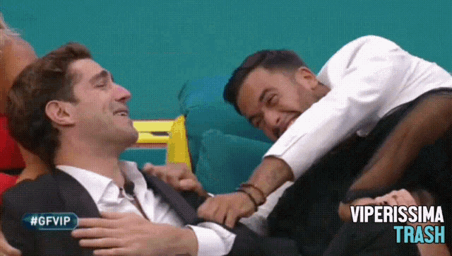 a man is laying on another man 's lap with the words #gfvip on the bottom