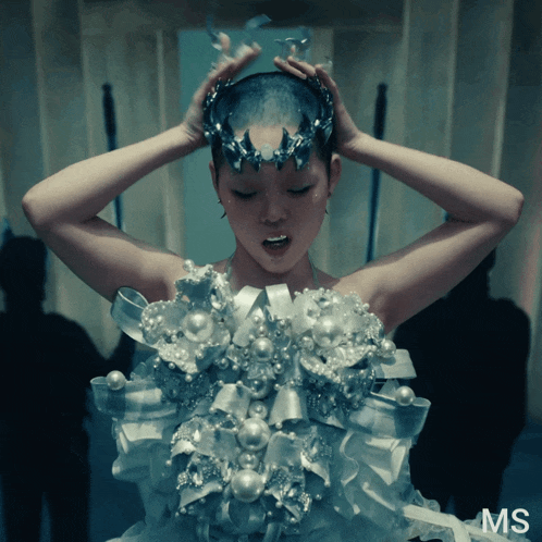 a woman with a crown on her head is wearing a dress that says ms on it