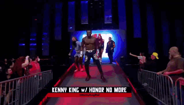 a wrestler named kenny king walks down the aisle at a wrestling event