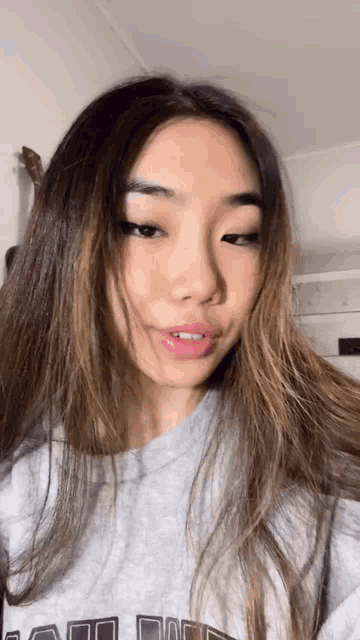 a close up of a woman 's face wearing a grey sweatshirt .