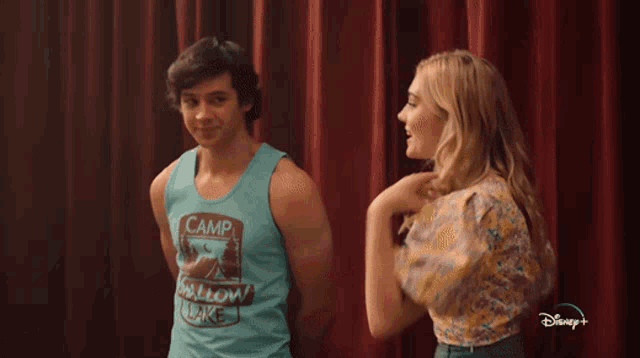 a man in a blue tank top that says camp shallow lake