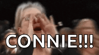 a woman is screaming in a crowd while holding her hands to her face and the word connie is visible .