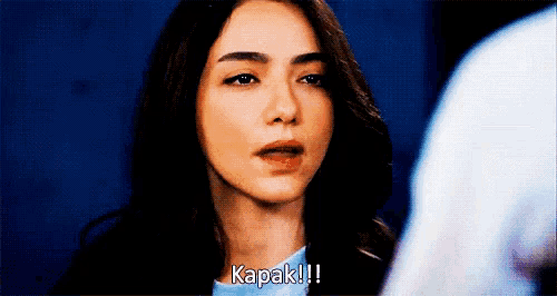a close up of a woman 's face with the words " kapak !!! " written on it .