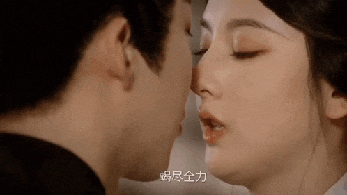 a man and a woman are kissing with chinese writing on the bottom right