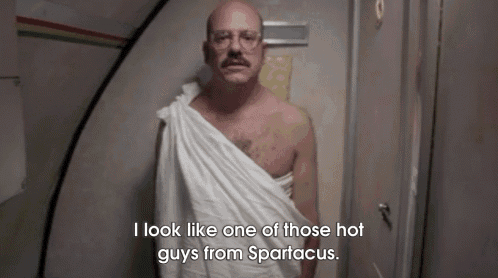a bald man with glasses and a towel around his neck says i look like one of those hot guys from spartacus .