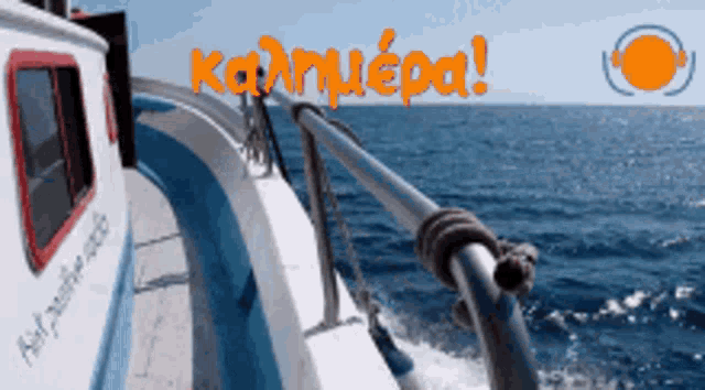 a blue and white boat in the ocean with the words kalimera in orange