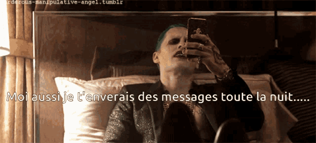 a man in a joker costume is looking at his cell phone