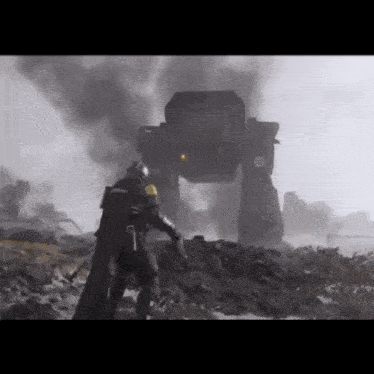 a man in a helmet is standing in front of a giant robot .