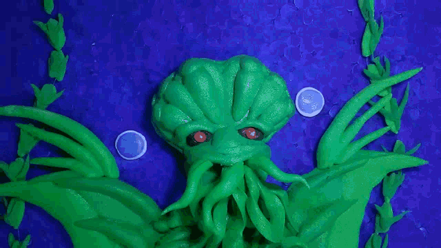 a green creature with red eyes is surrounded by blue bubbles