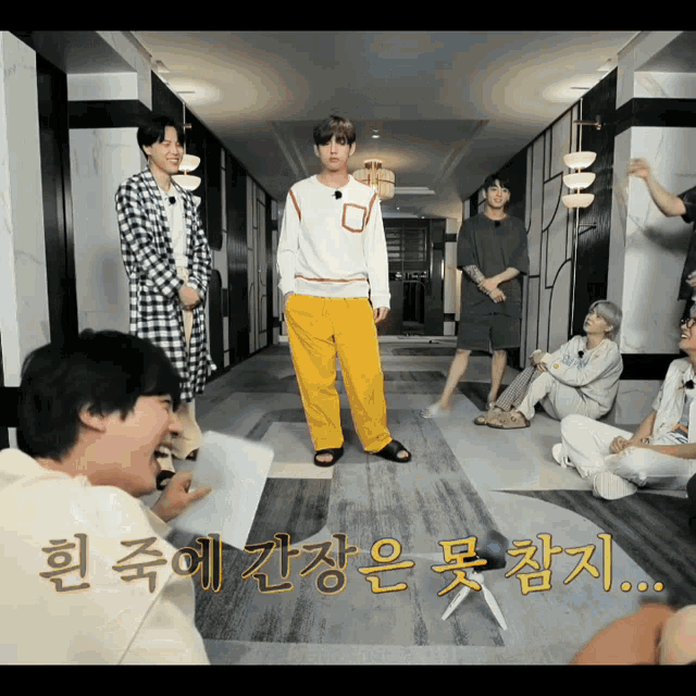 a group of young men are standing in a hallway with korean writing on the floor