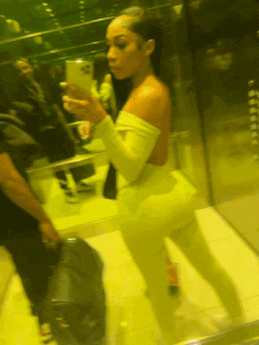 a woman taking a selfie in front of a mirror