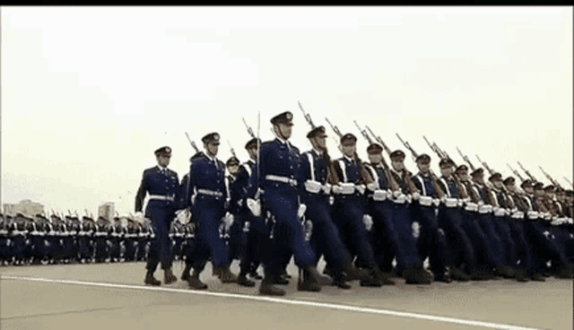 a large group of soldiers marching in a line with guns