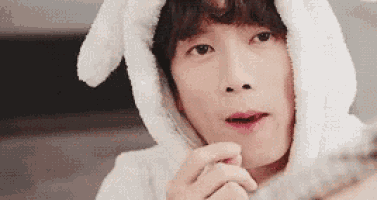 a close up of a person wearing bunny ears and a hood .