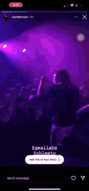 a phone screen shows a group of people dancing in a dark room