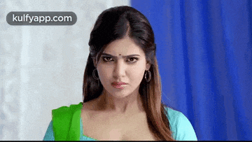 a close up of a woman 's face with a blue background and the words kulfyapp.com on the bottom .