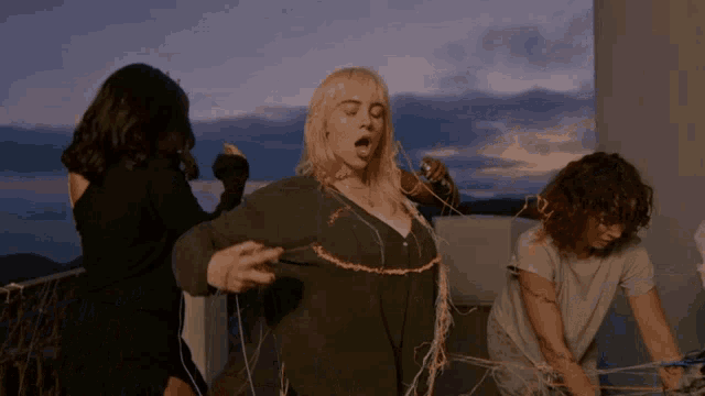 billie eilish is surrounded by two other women
