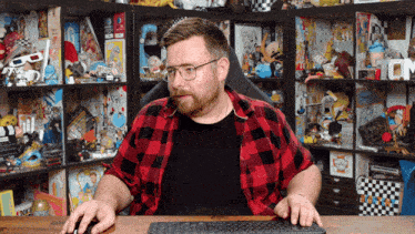 a man in a plaid shirt is using a keyboard
