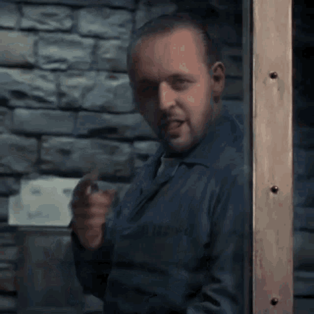 a man in a prison uniform has the letters a.b. on his shirt