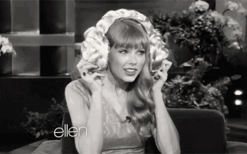 a black and white photo of a woman wearing a wig on a show .