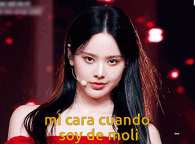 a woman in a red dress stands in front of a microphone with the words mi cara cuando soy de moli above her