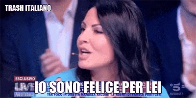 a woman in a blue dress is talking into a microphone with the words trash italiano on the bottom right