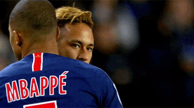 two soccer players one of whom has the name mbappe on his shirt