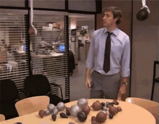 a man in a tie stands in front of a table filled with balls
