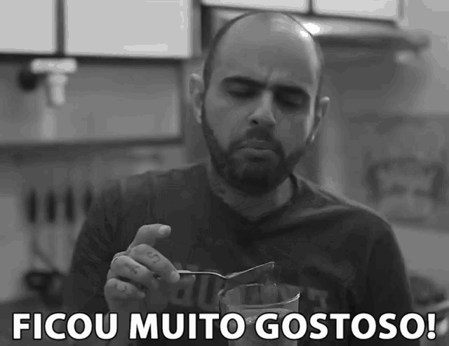 a man with a beard is holding a spoon in a glass with the words " ficou muito gostoso " above him