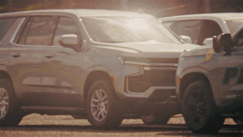 a white suv is parked next to a white suv with the letter p on it