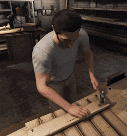 a man is hammering a piece of wood with a mallet