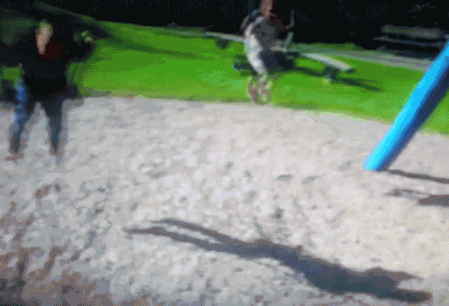 a blurry picture of people swinging on a swing set in a park