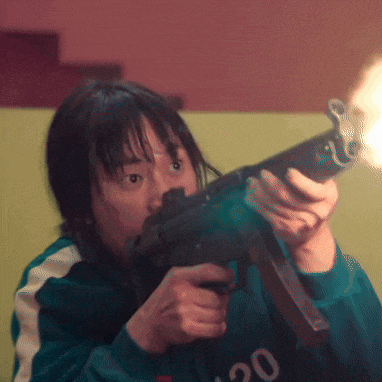 a woman holding a gun with the number 20 on her sweater