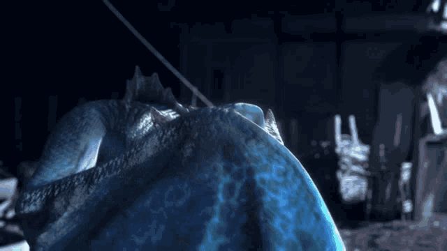 a blue monster is laying on the ground with a rope around it