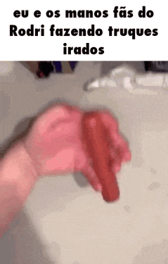 a person is holding a red object in their hand in front of a sink .
