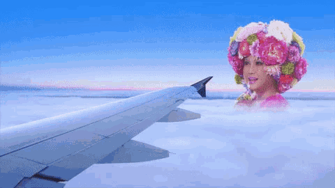 a woman with flowers in her hair is flying in the air