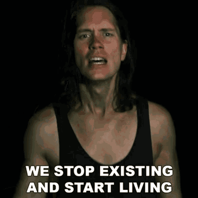 a man in a black tank top with the words we stop existing and start living below him
