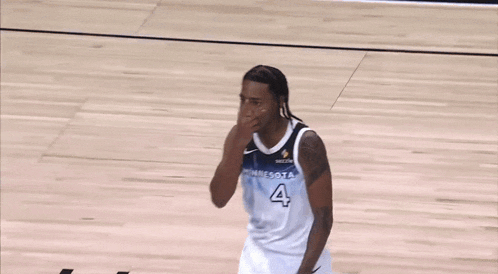 a basketball player wearing a minnesota jersey covering his nose