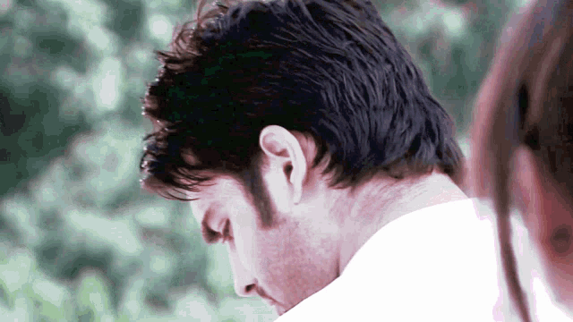 a close up of a man 's head with a woman behind him